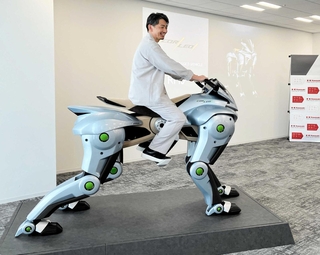 川崎重工業が開発を進める未来の乗り物「コルレオ」の模型にまたがる天辰祐介セーフアドベンチャー事業総括部長（同社提供）