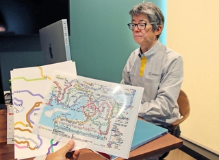 エグゼクティブデザイナーの大森正樹さんと、大森さんが手がけたＪＲ西日本の路線図＝神戸市中央区港島南町７