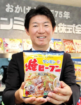 ケンミン食品が台湾で販売を開始した看板商品「ケンミン焼ビーフン」を持つ高村祐輝社長＝神戸市中央区海岸通５
