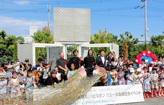 クラッカーを割って万博パビリオンの一部移設を祝う小学生ら＝神戸市西区室谷１、神鋼環境ソリューション技術研究所