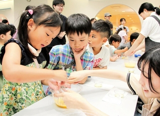 武庫川女子大のブースで、マヨネーズ作りを体験する子どもら＝西宮市北口町