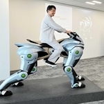 川崎重工業が開発を進める未来の乗り物「コルレオ」の模型にまたがる天辰祐介セーフアドベンチャー事業総括部長（同社提供）