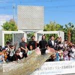 クラッカーを割って万博パビリオンの一部移設を祝う小学生ら＝神戸市西区室谷１、神鋼環境ソリューション技術研究所