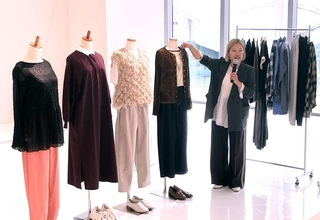 「セカンドサマー」プロジェクトの発表会で、見た目は秋物ながら涼しさを追求した服を紹介するフェリシモの担当者＝神戸市中央区新港町