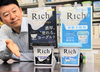 共進牧場「リッチ　ザ　ヨーグルト」の加糖タイプ（左）と砂糖不使用タイプを示す中尾弘三取締役営業本部長＝神戸市中央区橘通１、同社本社