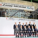 完成した水素エンジンの前で記念撮影する、ジャパンエンジンコーポレーションや川崎重工業の関係者＝明石市二見町南二見、ジャパンエンジンコーポレーション