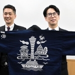 日本青年会議所の全国大会に向けて作った法被を手にする神戸青年会議所の松井隆昌理事長（右）と酒井博史大会実行委員長＝神戸市内