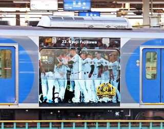 阪神タイガースのセ・リーグ連覇を祝ってラッピングされた車両。藤川球児監督らの写真があしらわれている＝７日午後、阪神尼崎駅
