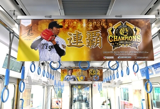 阪神タイガースのリーグ連覇を祝って選手らのポスターで飾られた車両内＝７日午後、尼崎市北城内、阪神電鉄尼崎車庫（撮影・斎藤雅志）