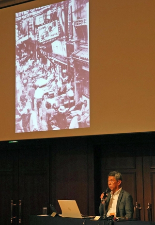 戦前の南京町のスライドを映して講演する曹英生さん＝神戸市中央区波止場町５
