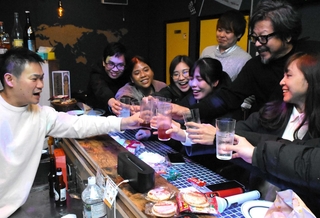 神戸の穴場を巡るツアーで訪れたカラオケバーで乾杯する訪日客ら。どんな感動を提供できるかが問われる＝神戸市中央区