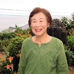 「海のそばにオレンジの花が広がる風景をもう一度見たい」と話す廣田久美さん＝淡路市釜口