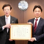 三菱ＵＦＪ銀行の北村慎取締役専務執行役員（右）に感謝状を手渡す神戸市の久元喜造市長＝大阪市中央区伏見町３