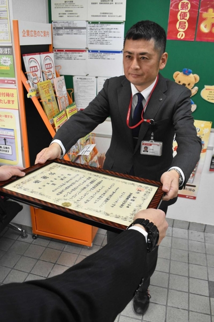 西宮署から感謝状を受け取る西宮鞍掛郵便局長の堀篤史さん＝西宮市久保町