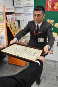 西宮署から感謝状を受け取る西宮鞍掛郵便局長の堀篤史さん＝西宮市久保町