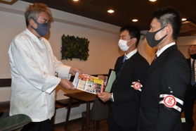 飲食店でチラシを手渡し、暴力団の情報提供を呼び掛ける署員ら＝西宮市今在家町