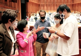 手作りマスクを贈った天野剛子さん（前列左から２番目）と、喜ぶ佐渡裕芸術監督（右端）ら＝兵庫県立芸術文化センター