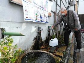 伊丹老松酒造の社屋の外にある「老松丹水」。連日、水をくみに訪れる市民が行列をつくる＝伊丹市中央３