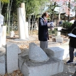 崩壊した鳥居で作られたモニュメント前で収録するパーソナリティーの大内康弘さん（中央）ら＝伊丹市荒牧３、天日神社