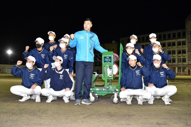 ピッチングマシンを寄贈した佐藤輝明選手を囲む野球部員たち＝西宮市甲東園２