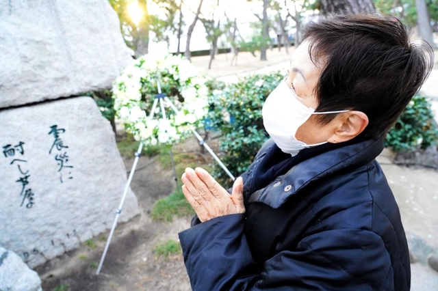 友人に囲まれて笑顔を浮かべる夫の姿を思い浮かべ、手を合わせる小笹昭子さん＝芦屋公園