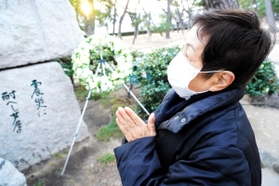 友人に囲まれて笑顔を浮かべる夫の姿を思い浮かべ、手を合わせる小笹昭子さん＝芦屋公園