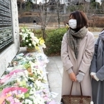 慰霊碑に刻まれた北田明代さんの名前を見つめる和田里佳子さんと瞳さん（右）＝西宮震災記念碑公園