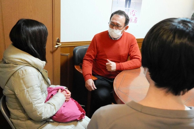 「生きている間に会いたいんです」。感染して入院している高齢の母親を在宅医療に切り替えられないかとの家族の相談に乗る長尾和宏院長（中央）＝尼崎市昭和通７、長尾クリニック