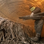 高温の窯の中で炭を運び出す作業に精を出す今西学さん＝川西市