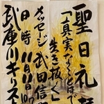水彩画を背景に、毛筆による力強い文字が書かれた看板＝尼崎市大島１、武庫川キリスト教会
