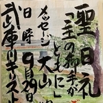 水彩画を背景に、毛筆による力強い文字が書かれた看板＝尼崎市大島１、武庫川キリスト教会