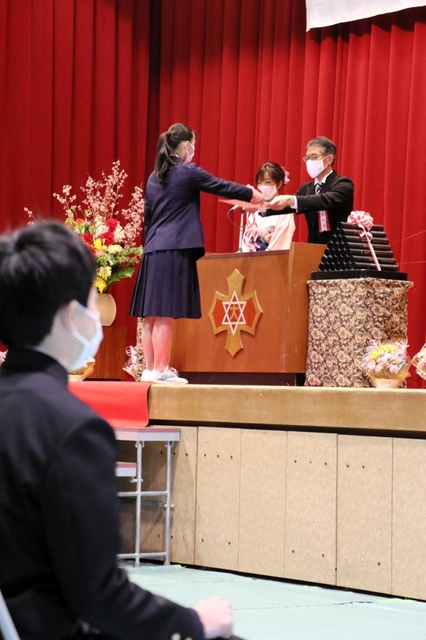 代表して壇上で卒業証書を受け取る卒業生＝西宮市神原、大社中学校