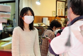 市場の鮮魚店主と談笑する婚活アイドルきっしー＝尼崎市杭瀬本町１