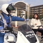 白バイ隊員が女性のながら運転を注意する場面（武庫川女子大学提供）