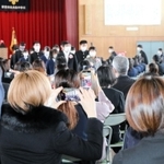 卒業式会場を後にする生徒を収めようとスマートフォンを構える保護者ら＝西宮市神原、大社中学校