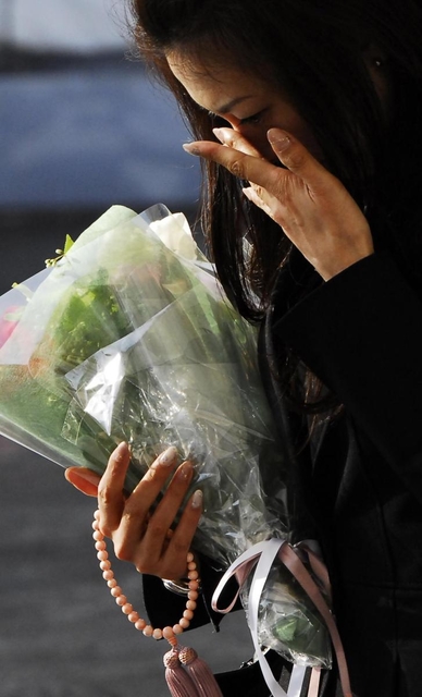 目頭を押さえ、現場に花を手向ける参列者＝２０１３年４月２５日午前７時３９分、尼崎市久々知３