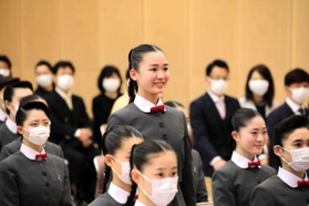 新型コロナ感染拡大防止のため、新入生徒紹介で名前を呼ばれ、立ち上がって会釈をする廣井すみれさん＝宝塚市武庫川町（宝塚音楽学校提供）