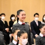 新型コロナ感染拡大防止のため、新入生徒紹介で名前を呼ばれ、立ち上がって会釈をする廣井すみれさん＝宝塚市武庫川町（宝塚音楽学校提供）