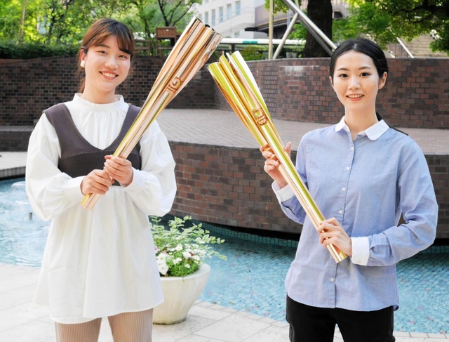 聖火を手にする梅谷星菜さん（右）と吉田智美さん＝西宮市池開町、武庫川女子大学