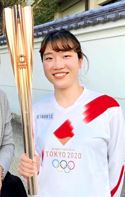 聖火を手に笑顔を見せる吉田智美さん（本人提供）