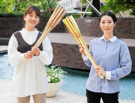 聖火を手にする梅谷星菜さん（右）と吉田智美さん＝西宮市池開町、武庫川女子大学