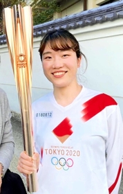 聖火を手に笑顔を見せる吉田智美さん（本人提供）