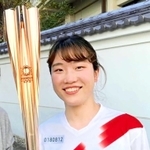 聖火を手に笑顔を見せる吉田智美さん（本人提供）
