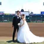グラウンドで結婚記念の写真を撮影する新郎新婦＝２３日、西宮市甲子園町、阪神甲子園球場