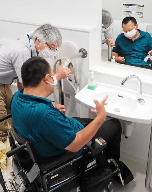 西宮市役所の第２庁舎内を車いすで見て回る大久保健一さん＝西宮市六湛寺町