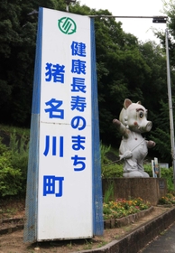 県道沿いに設置されている猪名川町のＰＲ看板。横には同町のマスコットキャラクター「いなぼう」の像も＝猪名川町差組