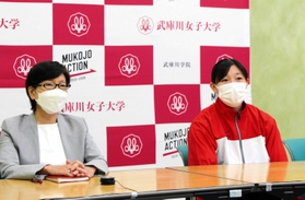 荒井にエールを送る武庫川女子大学水泳部の田嶋恭江部長（左）と長島知里主将＝同大学（提供）