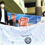 堂安律選手へのメッセージ入り応援旗を持つ兄の憂さん（左）＝あまがさきキューズモール