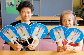 玉井陸斗を応援する特製うちわを持つ高司小学校区まちづくり協議会の津国千恵子事務局長（左）と平石美佐子副会長＝宝塚市高司２、高司中学校