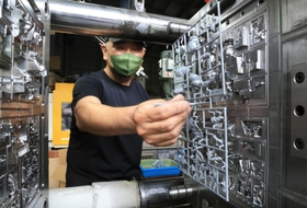 金型からプラモデルのパーツを外す宮本景根工場長＝山八化成工業所（撮影・斎藤雅志）